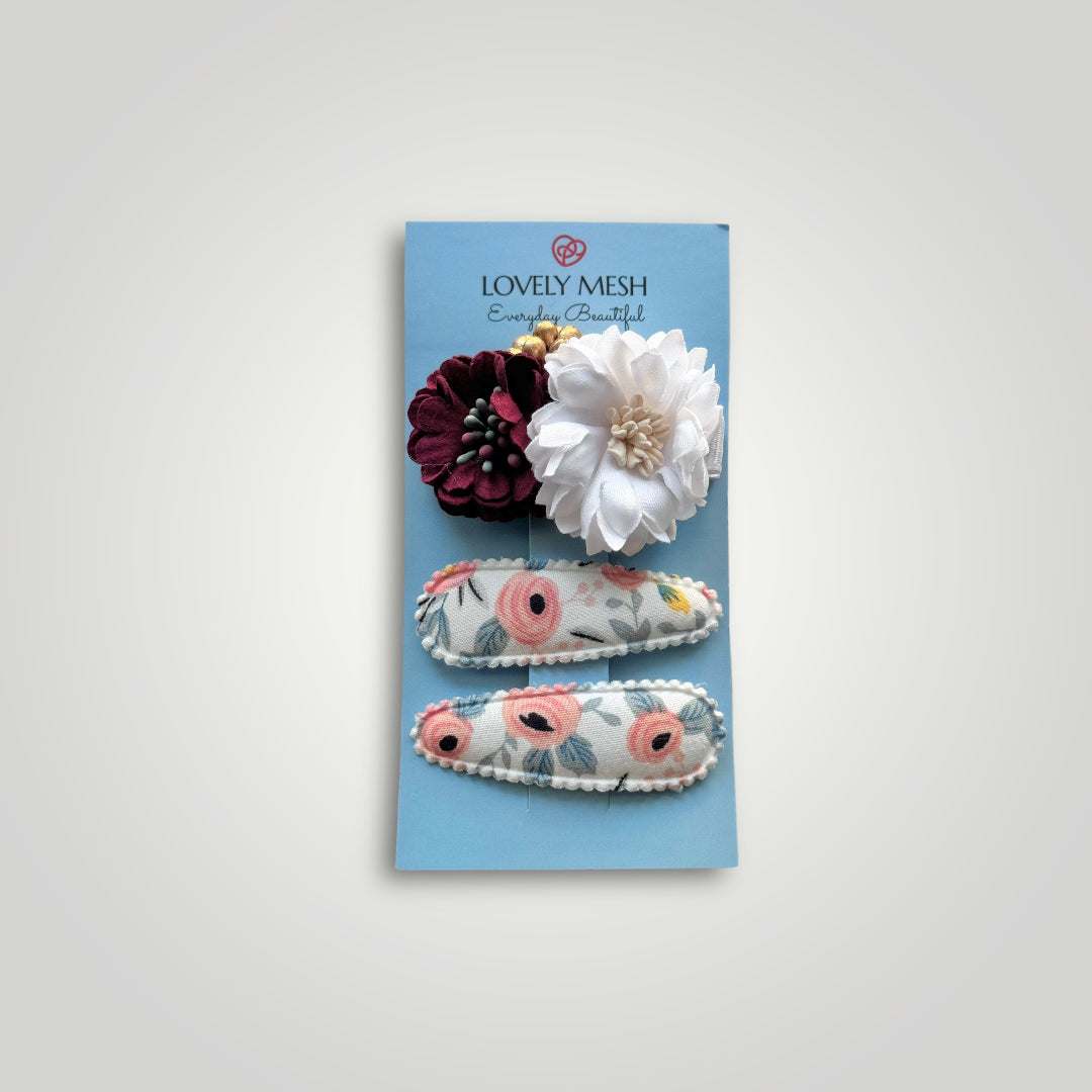 Set of 3 clips; 1 snap clip with a red and a white flower and 2 snap clips covered with fabric with flowers pattern.