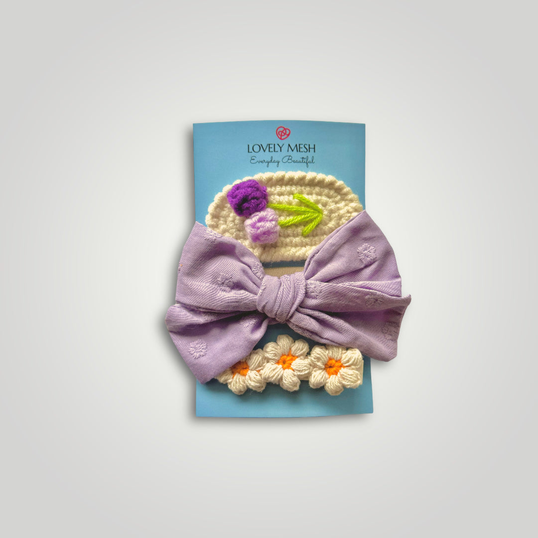 1 embroidered gauze bow in a soft headband with 2 crocheted clips, one with flowers and one with fruits. Colors: Purple, lila, off white and orange.