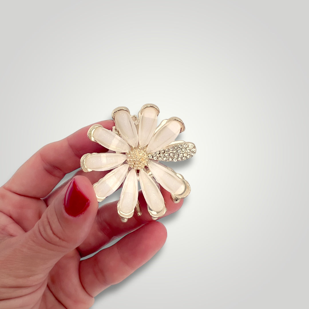 A golden metallic flower claw clip with crystal petals.