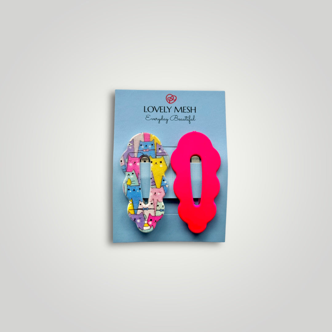 A pair of funky snap clips, colors: bright pink and multicolored cats pattern.