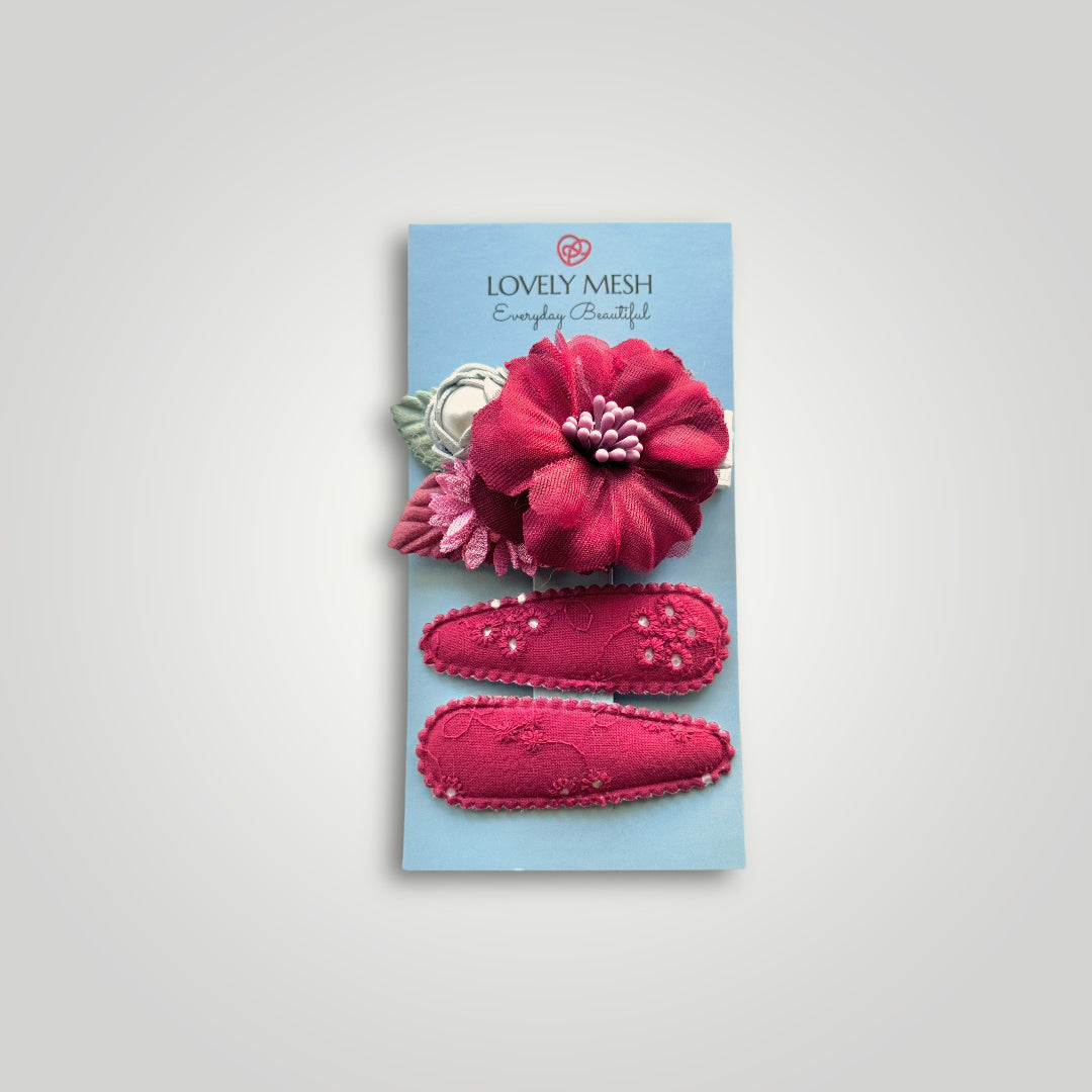 Set of 3 clips; 1 snap clip with a red and a blue flower with a pearl and 2 snap clips covered with embroidered red fabric.