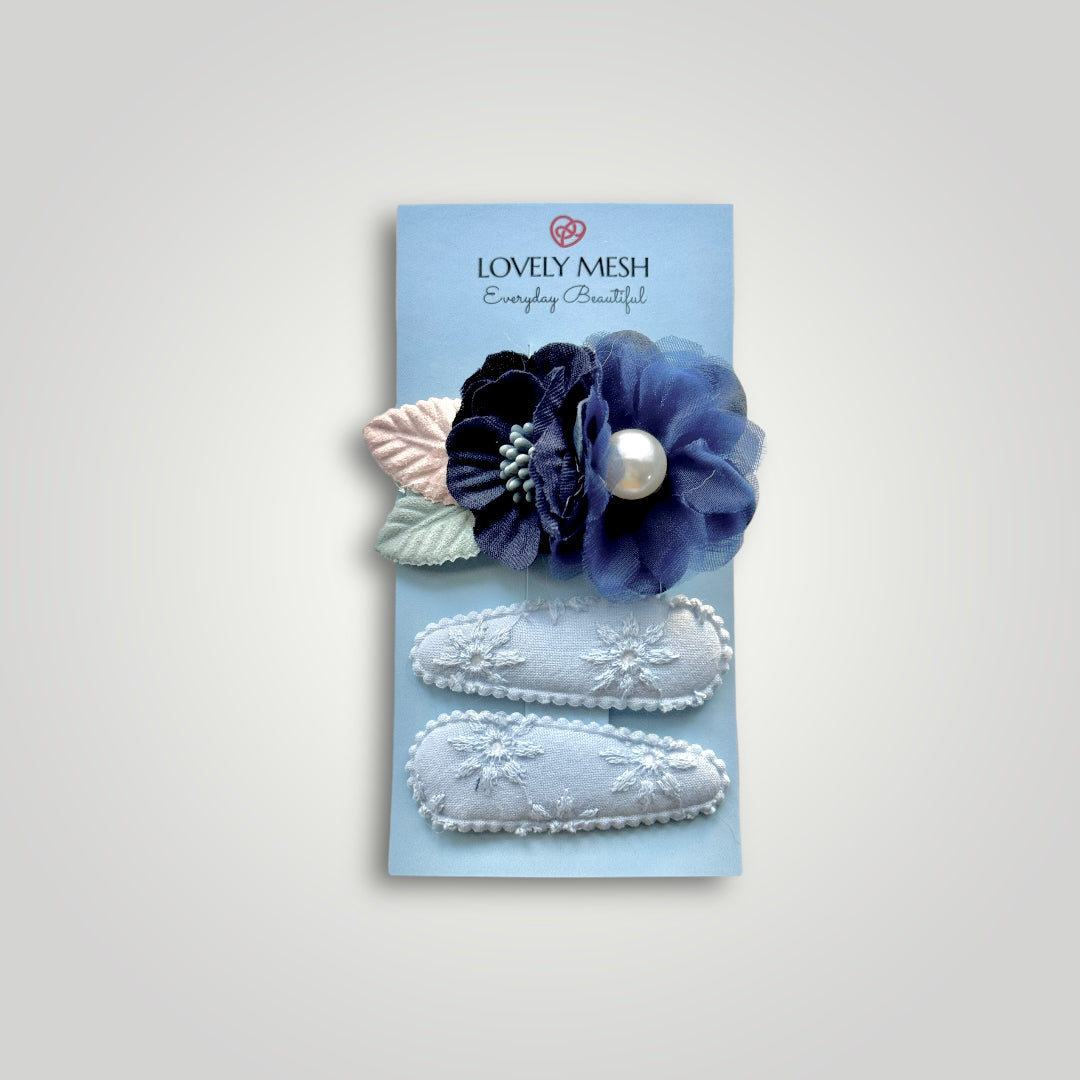 Set of 3 clips; 1 snap clip with blue flowers with a pearl, and 2 snap clips covered with baby blue embroidered fabric.