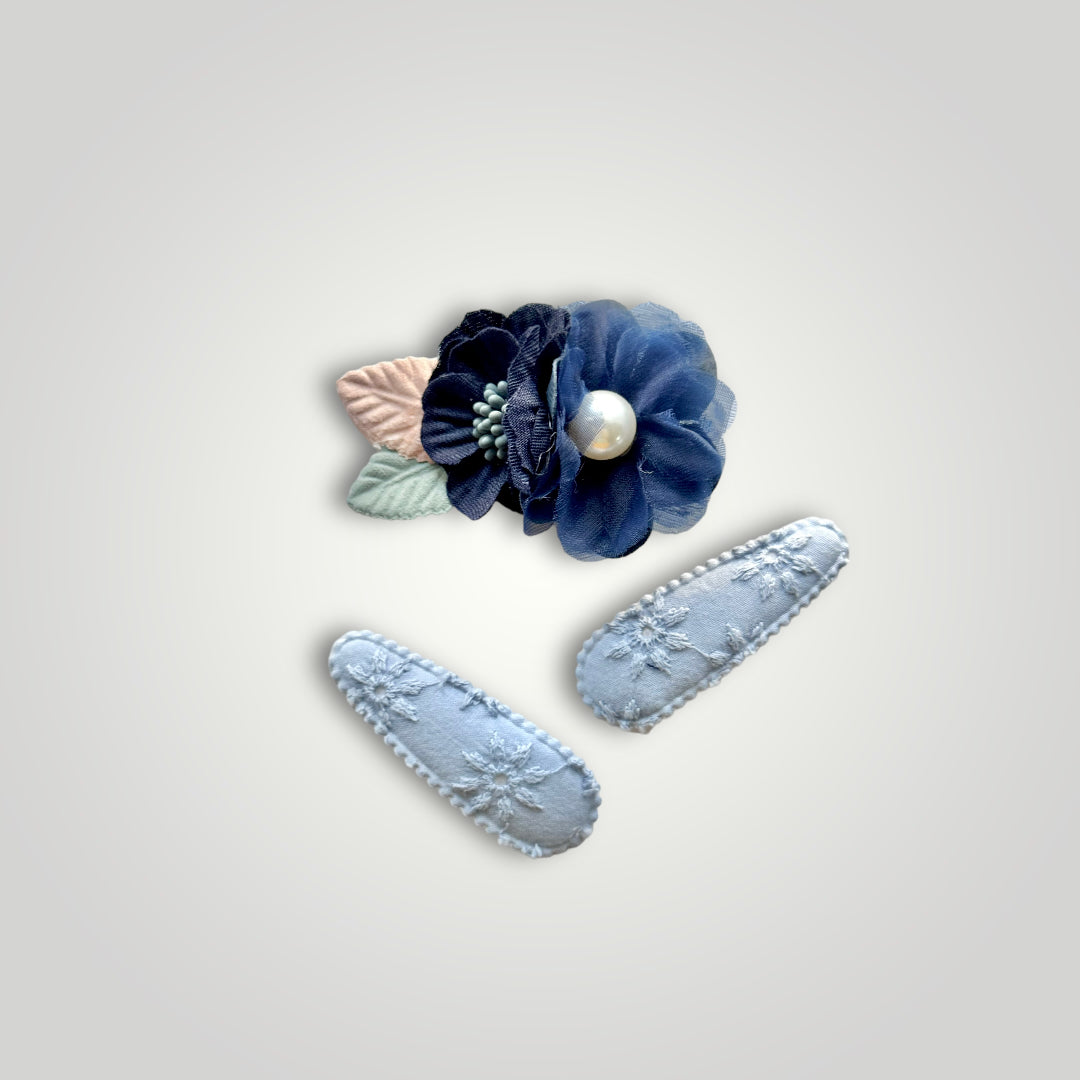 Set of 3 clips; 1 snap clip with blue flowers with a pearl, and 2 snap clips covered with baby blue embroidered fabric.